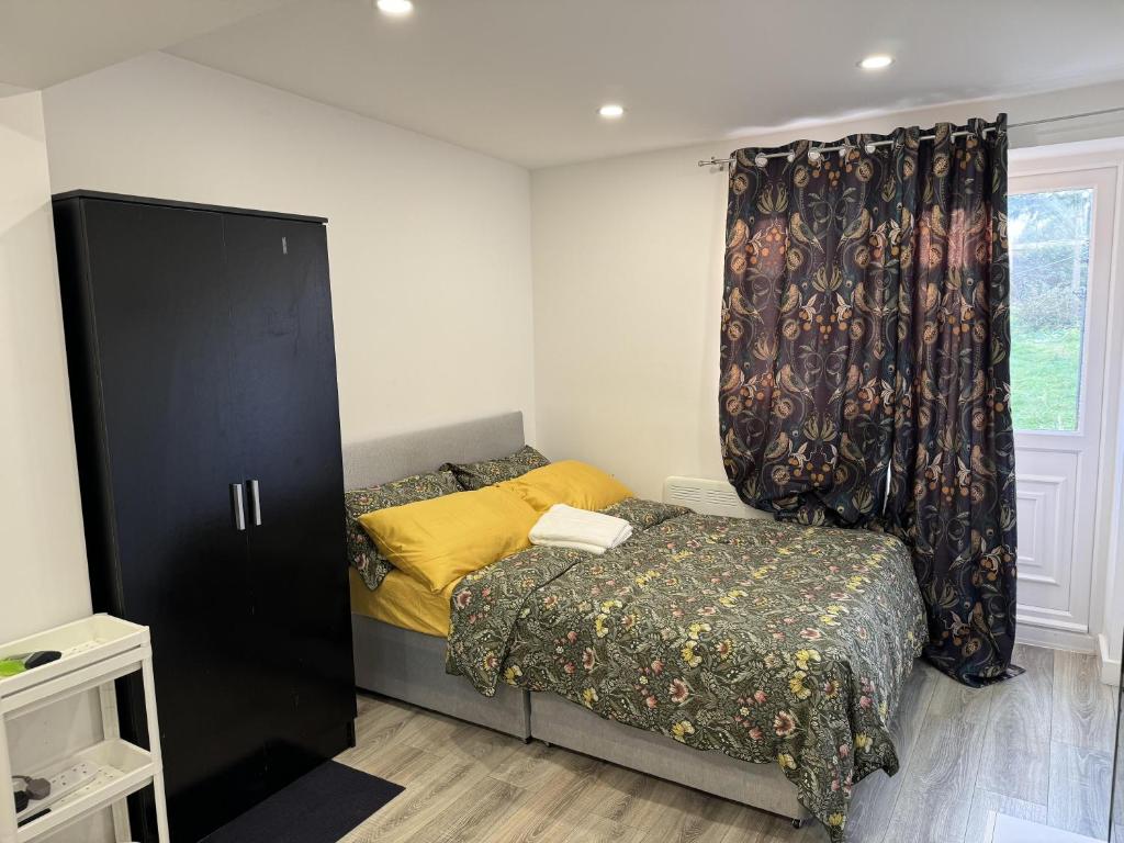 niewielka sypialnia z łóżkiem i oknem w obiekcie Impeccable 5-Bed House in Orpington w mieście Orpington