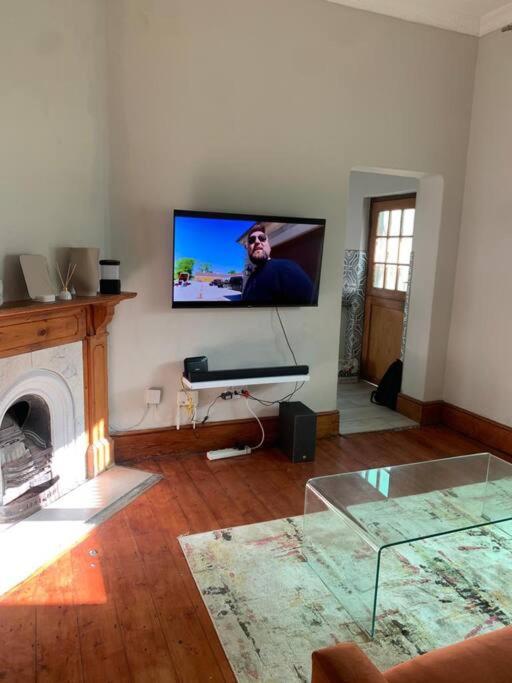 a living room with a flat screen tv on the wall at Victorian Haven in Observatory in Cape Town