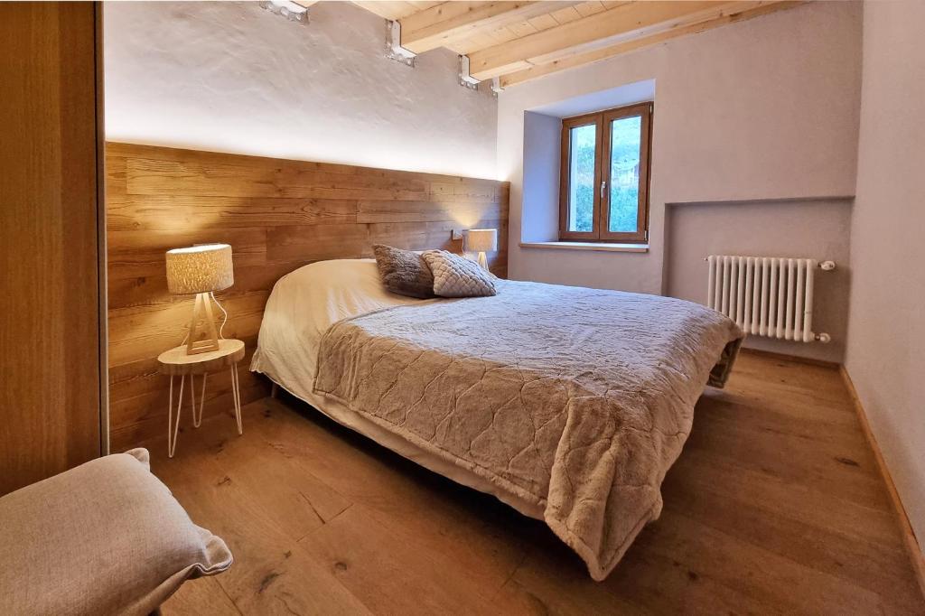 una camera da letto con un letto, una lampada e una finestra di Alpine Chic Retreat a Courmayeur
