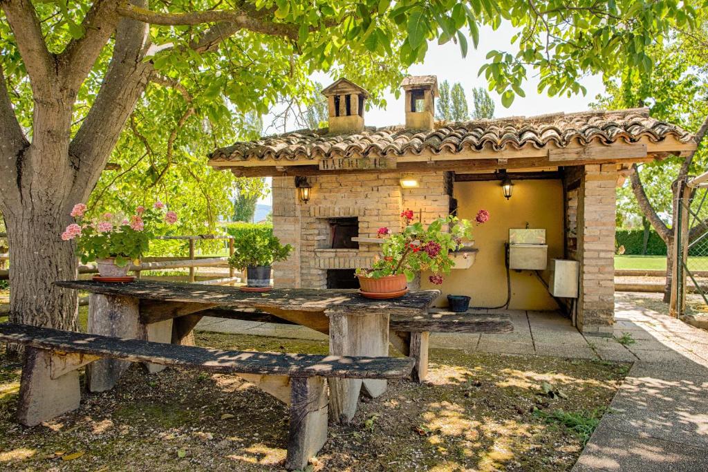 uma pequena casa com uma mesa em frente em Agriturismo La Mora - Gemelli em Assis
