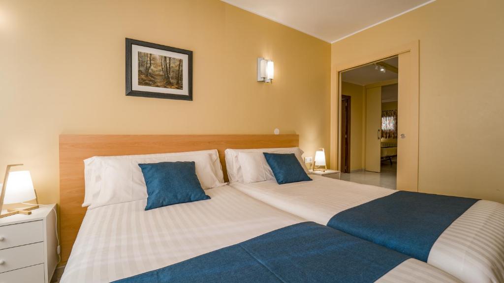 una camera da letto con un grande letto con cuscini blu di Apartaments Del Meligar a Encamp