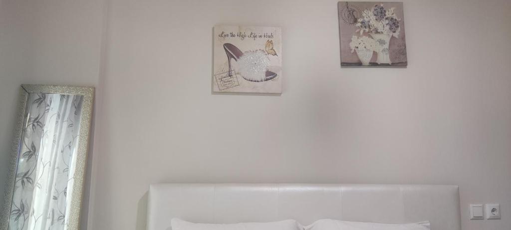 three pictures on a white wall above a bed at ΠΟΛΥΤΕΛΕΣ -ΜΟΝΤΕΡΝΟ ΔΙΑΜΕΡΙΣΜΑ in Larisa