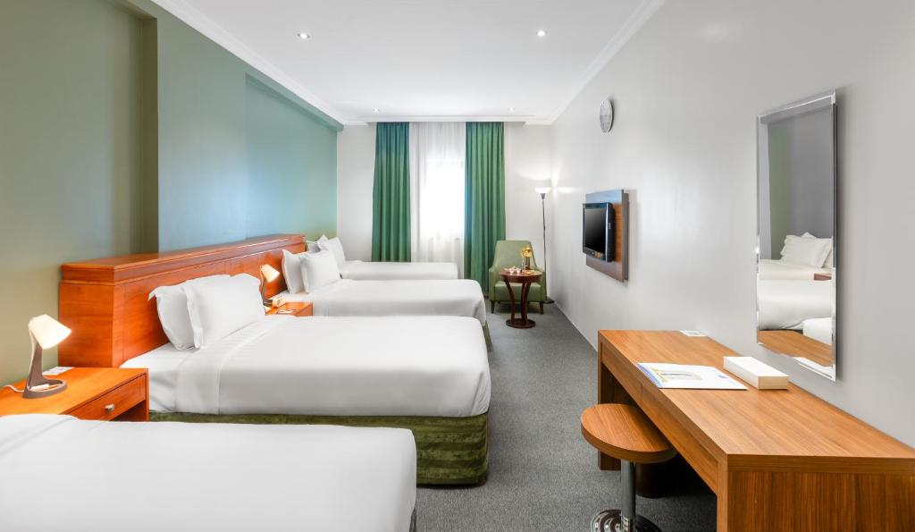 Cette chambre comprend deux lits et un bureau. dans l'établissement Barakat Burhan Hotel, à La Mecque