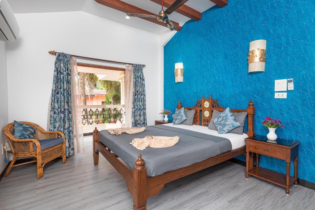 a bedroom with a bed and a blue wall at Villa Calangute Phase 1 in Calangute