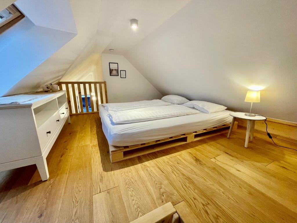 um quarto com uma cama e uma cómoda num sótão em Destino in der ehemaligen Waage der Roomerie em Sulzbach-Rosenberg