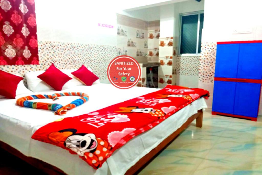 a bedroom with a bed with a hello kitty blanket at Goroomgo Pranab Sadan Puri in Puri