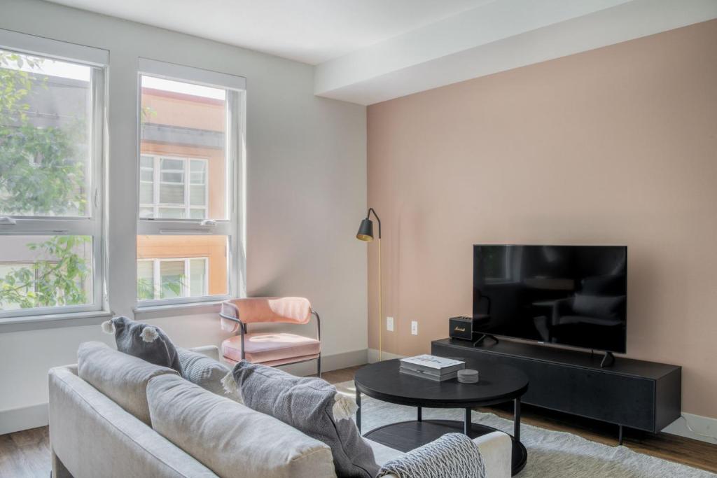 ein Wohnzimmer mit Sofa und Fernseher in der Unterkunft Bellevue jr 1br w lounge gym nr coffee shops SEA-612 in Bellevue
