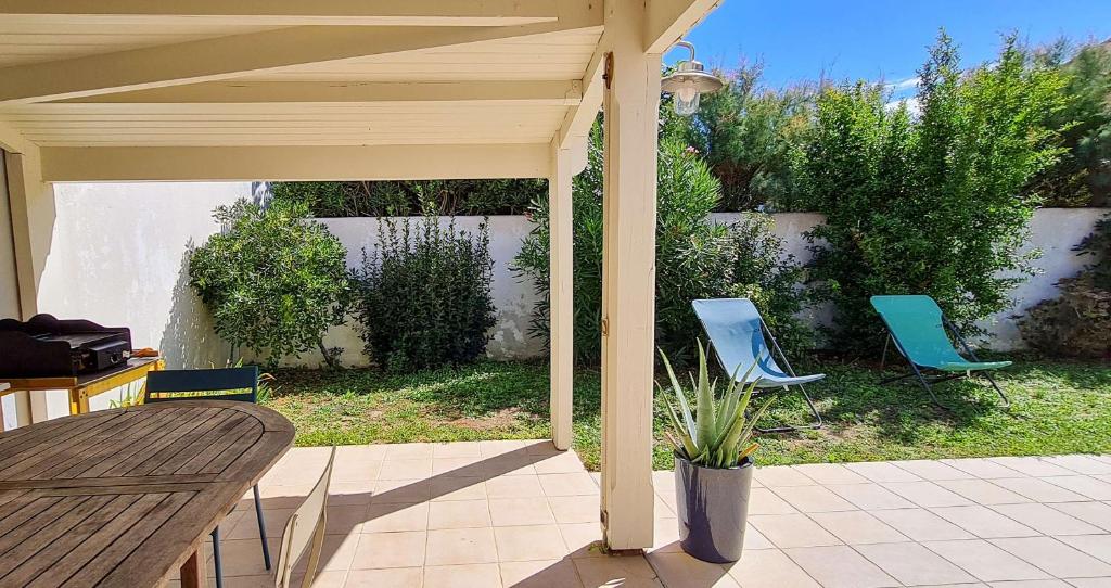 - deux chaises bleues assises sous un pavillon sur une terrasse dans l'établissement Dans le centre du village de La Couarde, charmante ville de plain pied, à La Couarde-sur-Mer