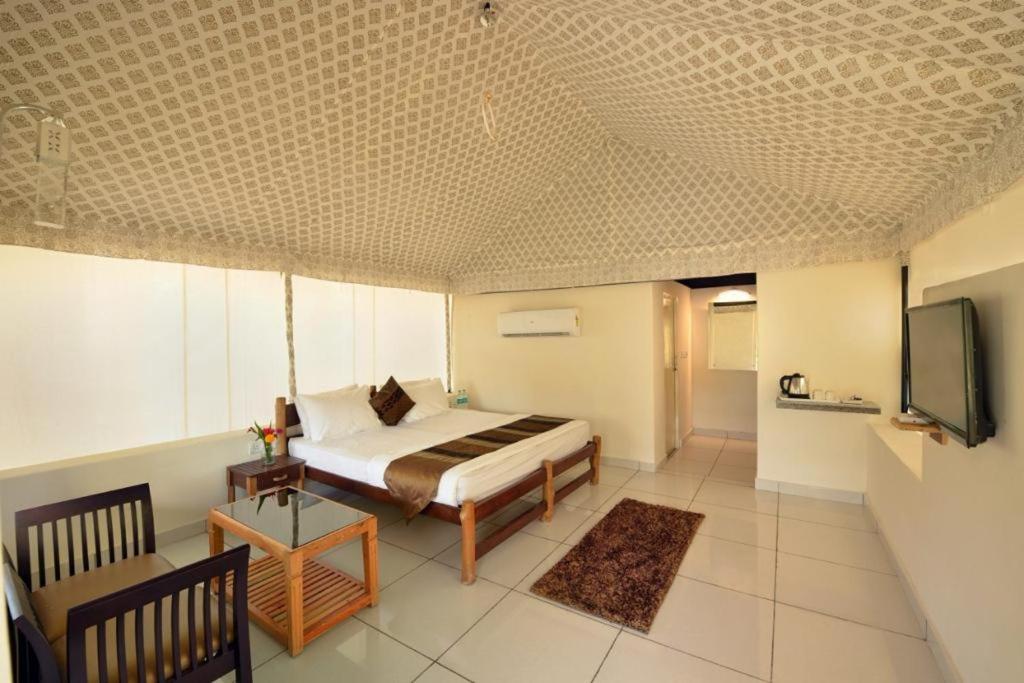 a bedroom with a bed and a tv in it at BENTO CORBETT WOODS RESORT in Jhirna