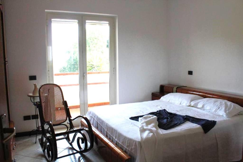 a bedroom with a bed and a chair and a window at 80 m² Vista Mare in Policastro Bussentino