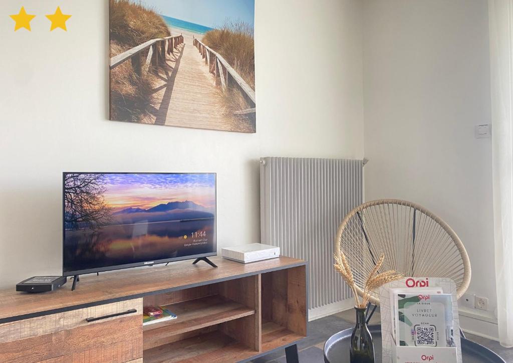 un salon avec une télévision sur une table en bois dans l'établissement La Digue, à Calais