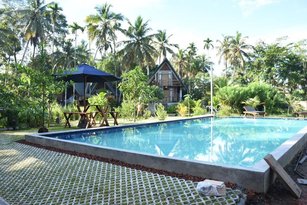 a large swimming pool in front of a house at Steps Garden Resort in Negombo