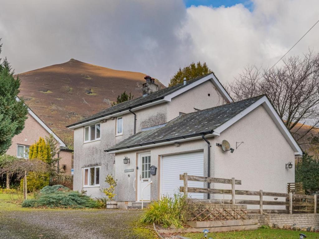 a white house with a garage in front of a mountain at 3 Bed in Keswick oc-sz047 in Threlkeld