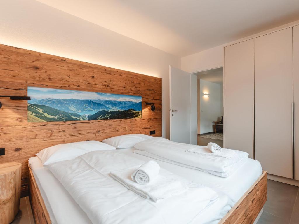 a bedroom with two white beds with a wooden wall at Apartment Das Georgen- Schmitten by Interhome in Fürstau