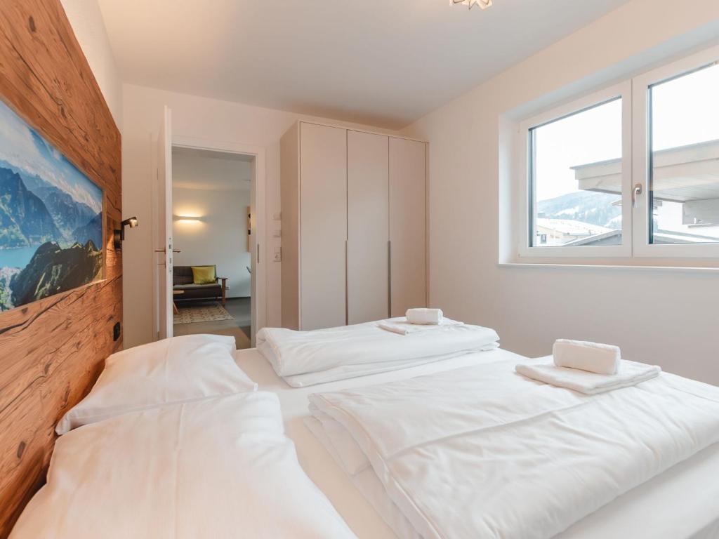 two beds in a white room with a window at Apartment Das Georgen- Schmitten by Interhome in Fürstau