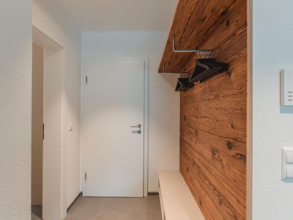 a pivot door in a room with white walls and wood at Apartment Das Georgen- Schmitten by Interhome in Fürstau