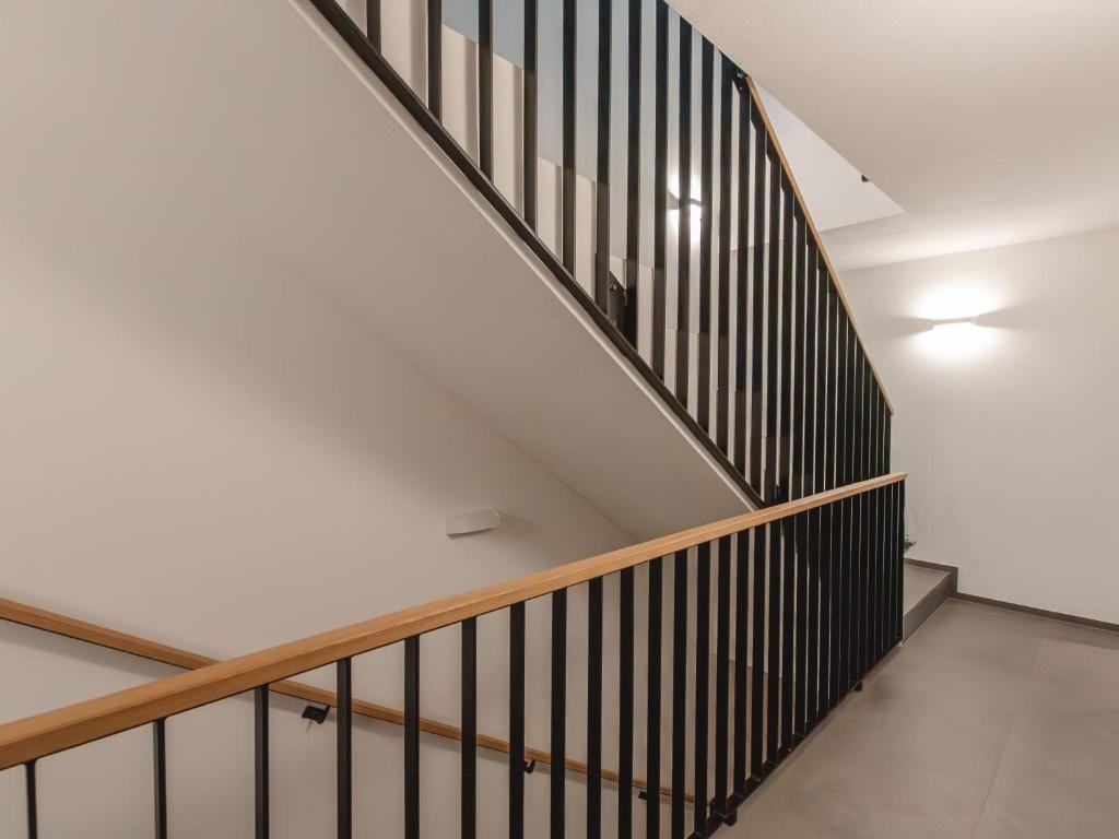 a staircase in a house with white walls and wooden railings at Apartment Das Georgen- Schmitten by Interhome in Fürstau