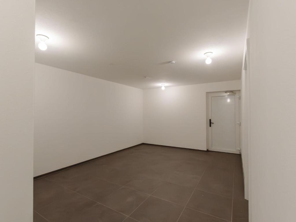 an empty room with white walls and a tile floor at Apartment Das Georgen- Schmitten by Interhome in Fürstau