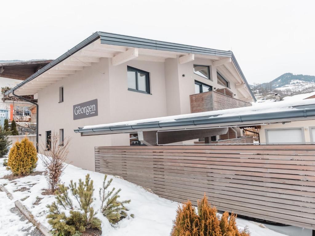 a house with a fence in the snow at Apartment Das Georgen- Schmitten by Interhome in Fürstau