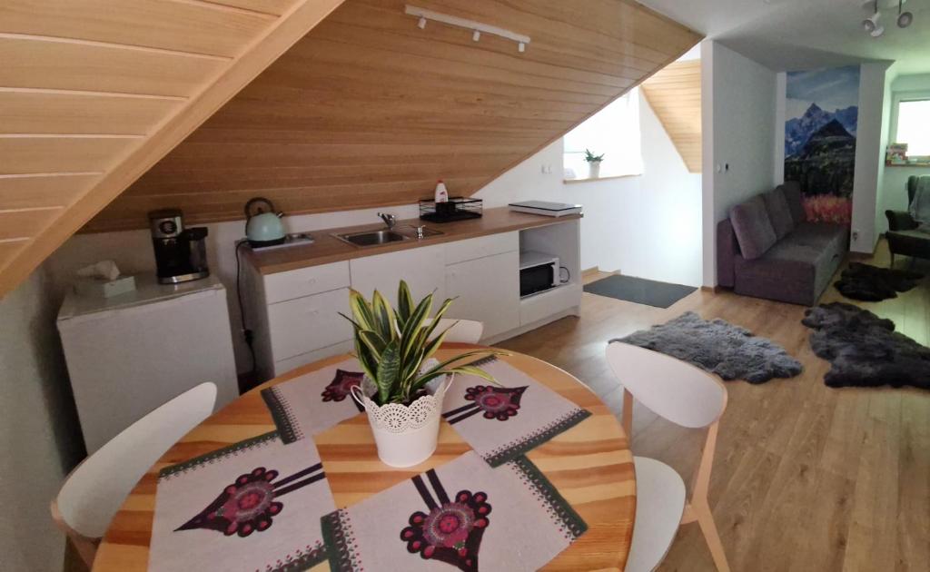 a kitchen and dining room with a table and chairs at Apartament Grel in Nowy Targ