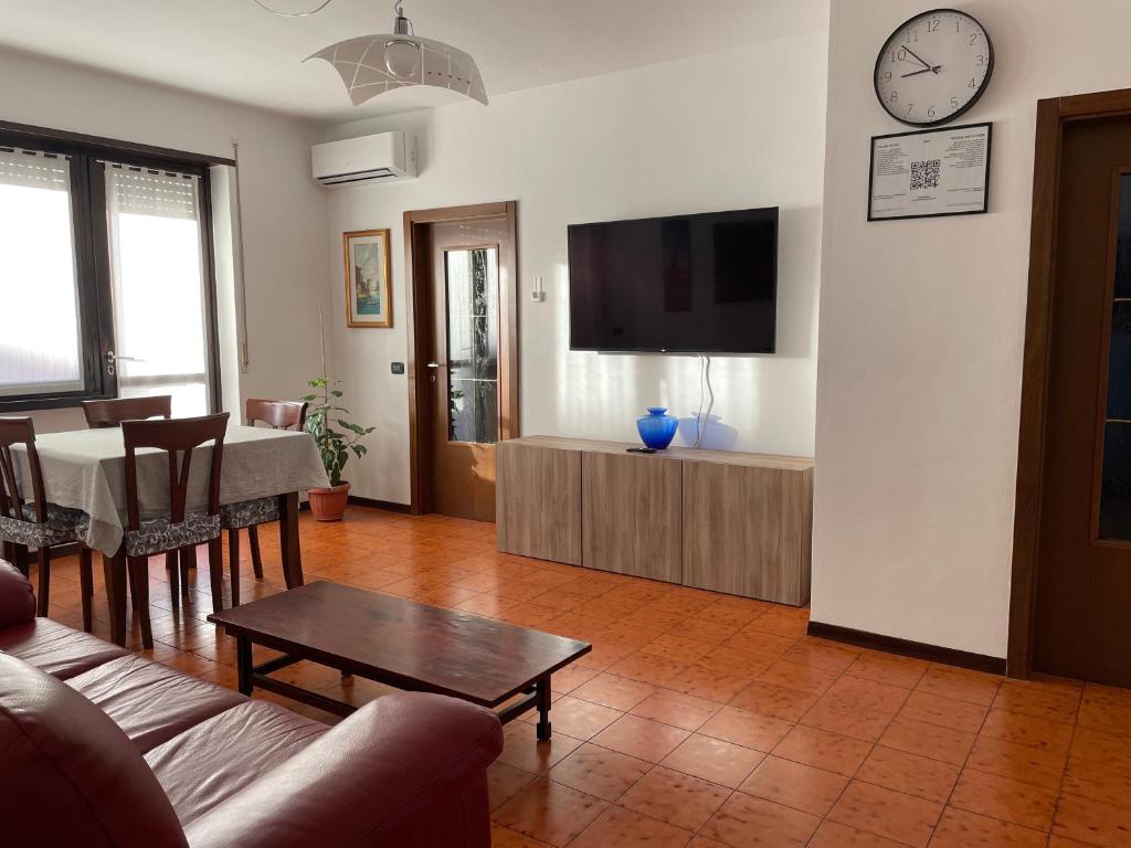 een woonkamer met een bank, een tafel en een tv bij Appartamento spazioso con 3 camere da letto in Riva del Garda