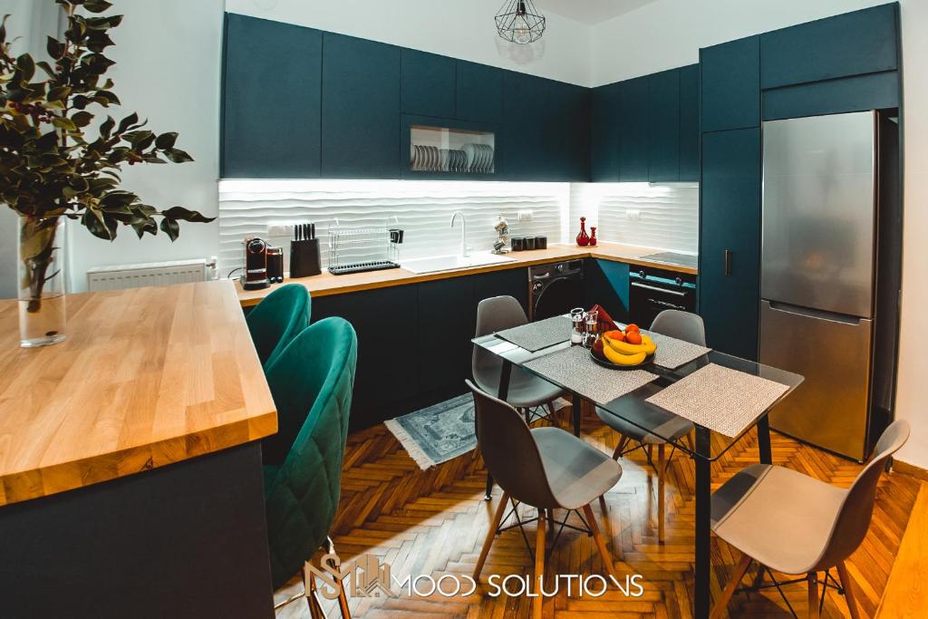 a kitchen with blue cabinets and a table and chairs at FirstLineSkg3 Moodsolutions Living in Thessaloniki