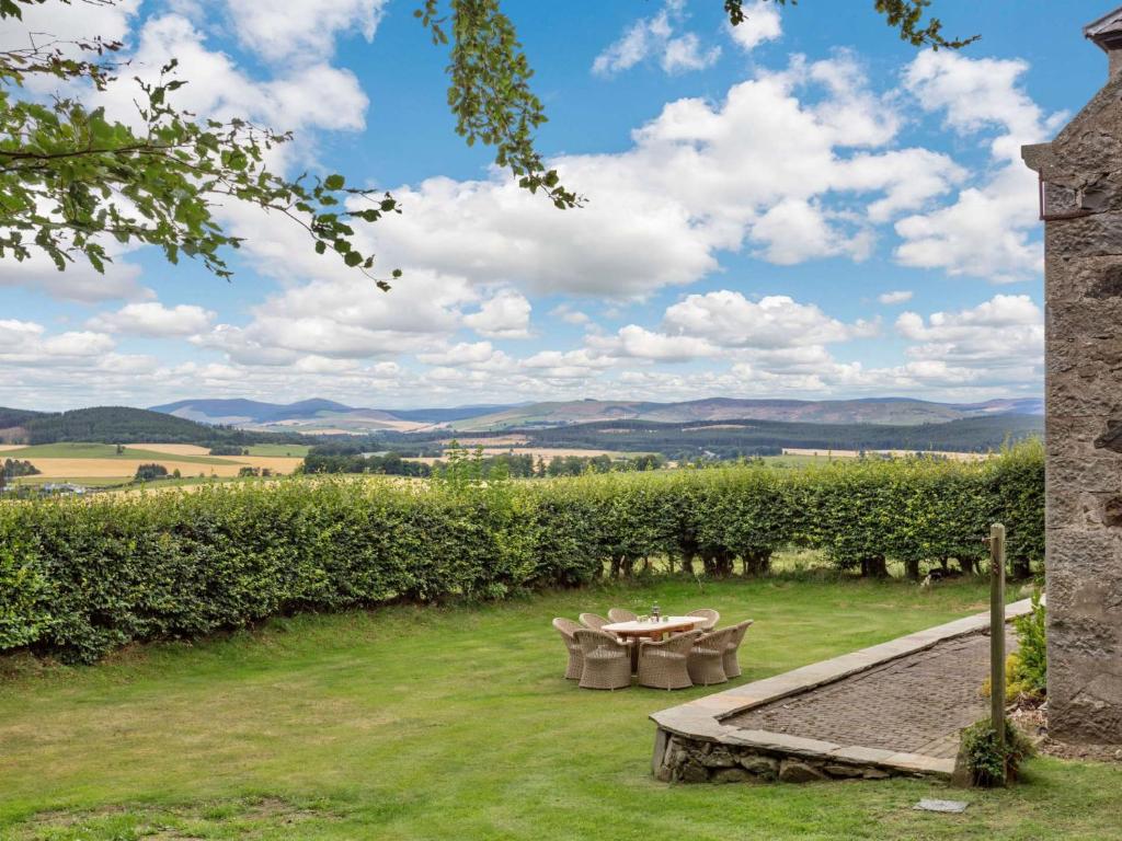 a garden with a table and chairs in the grass at 4 Bed in Huntly 88855 in Inverurie