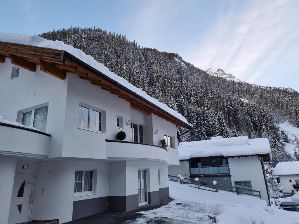 un edificio innevato con una montagna sullo sfondo di Apartment Christians Hamat by Interhome a Ischgl