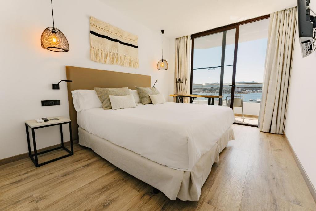 サンアントニオにあるHotel Sa Clau by Mamboのベッドルーム(大型ベッド1台、大きな窓付)