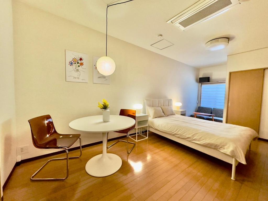 東京にあるCube Stay 北東京のベッドルーム1室(ベッド1台、テーブル、ベッド1台、テーブル付)
