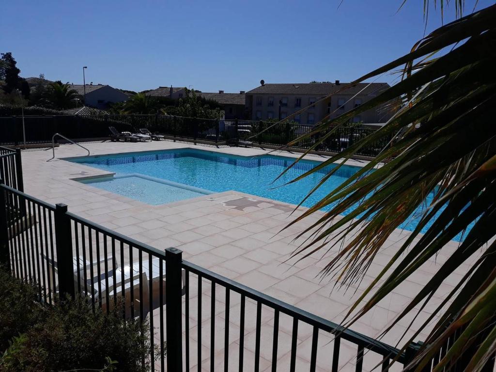 une grande piscine à côté d'une clôture dans l'établissement Appartement Les Issambres, 2 pièces, 4 personnes - FR-1-768-57, aux Issambres