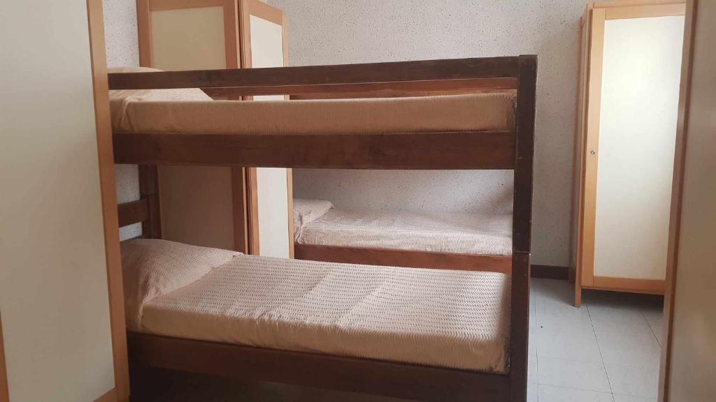 a couple of bunk beds in a room at La Baleine Blanche - Hostel in Campan