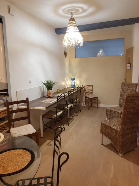 une salle à manger avec des chaises, une table et un lustre dans l'établissement L'Auberge du Docteur Privey - Free & secure Park Bike - Voie Bleue, à Tournus