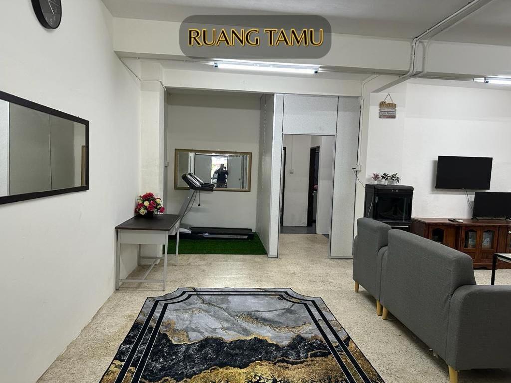 a living room with a couch and a rug at ALUNAN HOMESTAY in Kangar