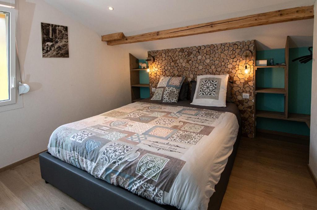 sypialnia z łóżkiem z drewnianą ścianą w obiekcie chambre d'hôtes nos racines (chez Muriel et Philippe) w mieście Saulxures-sur-Moselotte