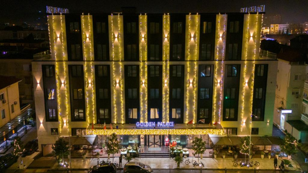 a building decorated with christmas lights at night at Hotel Golden Palace in Shkodër