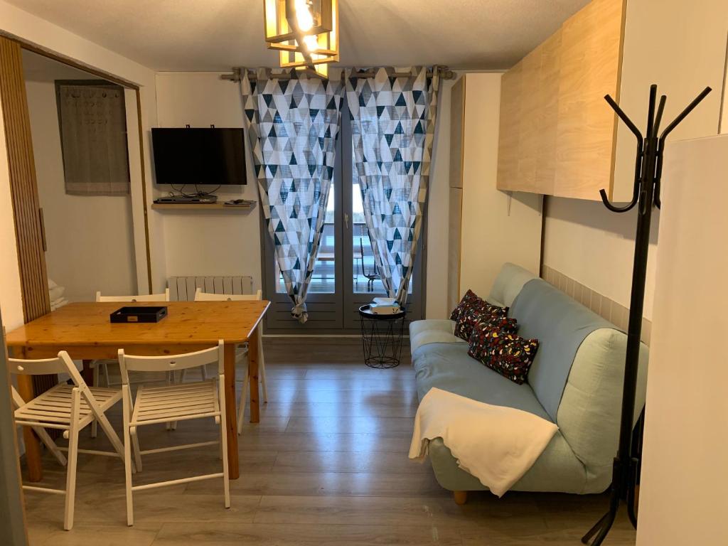 ein Wohnzimmer mit einem blauen Sofa und einem Tisch in der Unterkunft La Foux d’Allos, centre station proche pistes in Allos