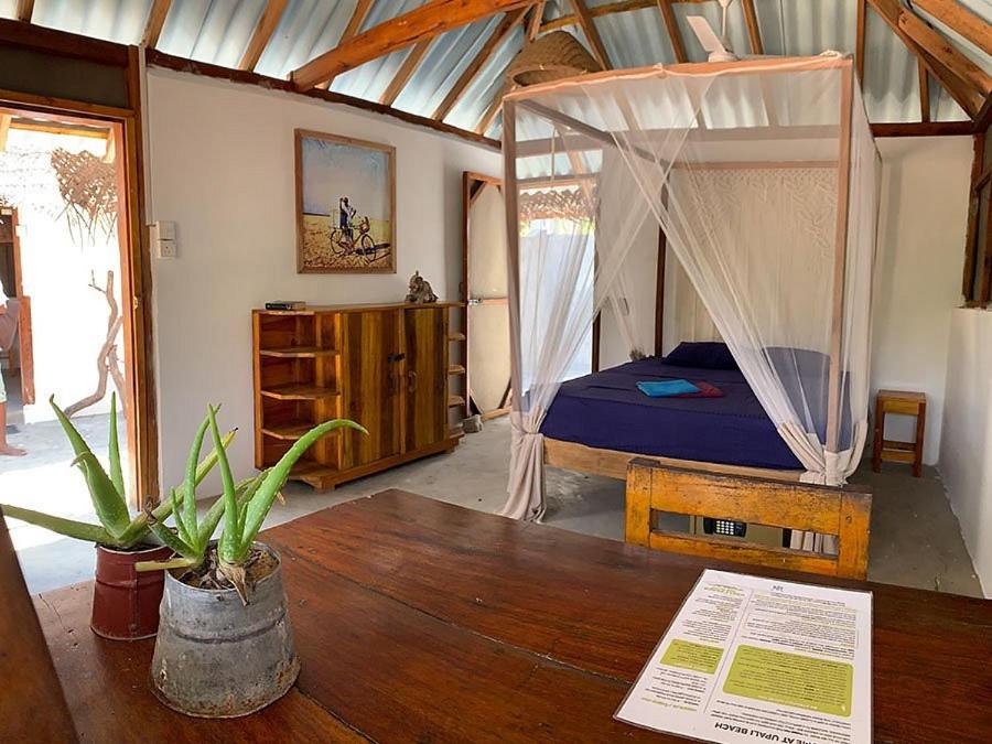 um quarto com uma cama de dossel e uma mesa em Upali Beach Surf Resort & Café em Arugam Bay
