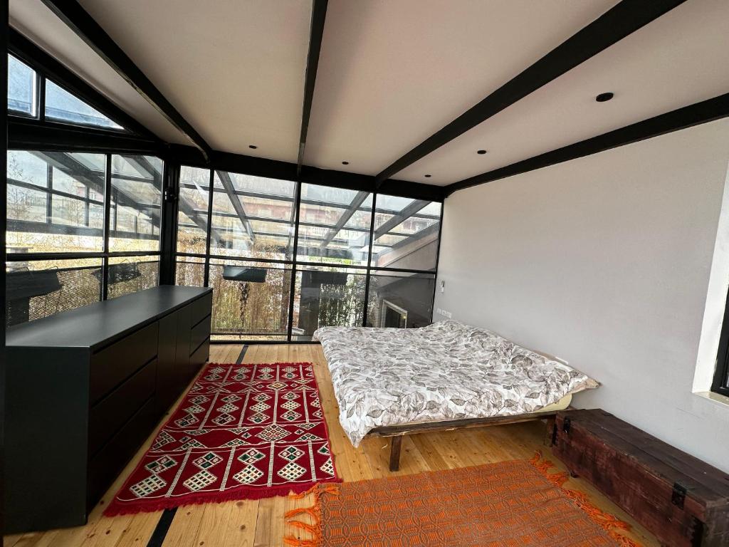 a bedroom with a bed in a room with windows at Botanic Loft in Tirana