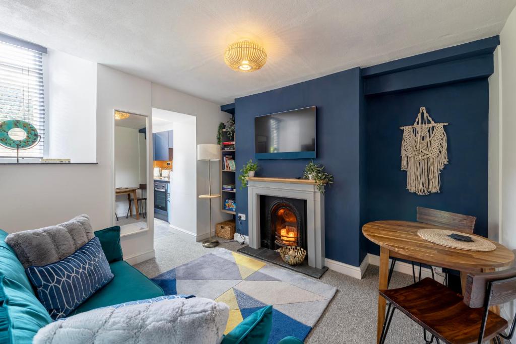a living room with a blue wall with a fireplace at Princes Street in the Heart of Bath in Bath