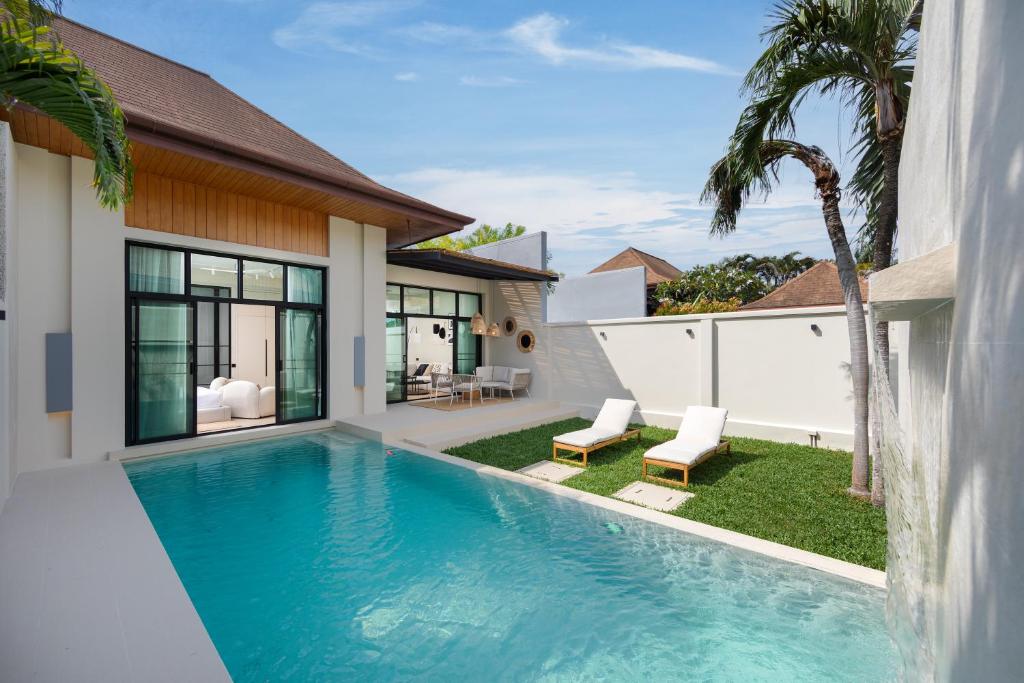 a swimming pool in the backyard of a house at Onyx Villas by TropicLook in Nai Harn Beach