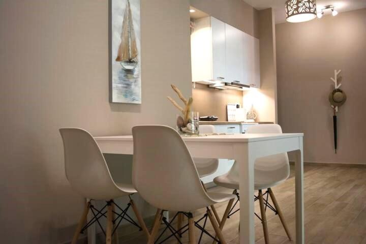 a kitchen with white chairs and a white table at Chic and Minimal apartment close to Thissio Metro in Athens