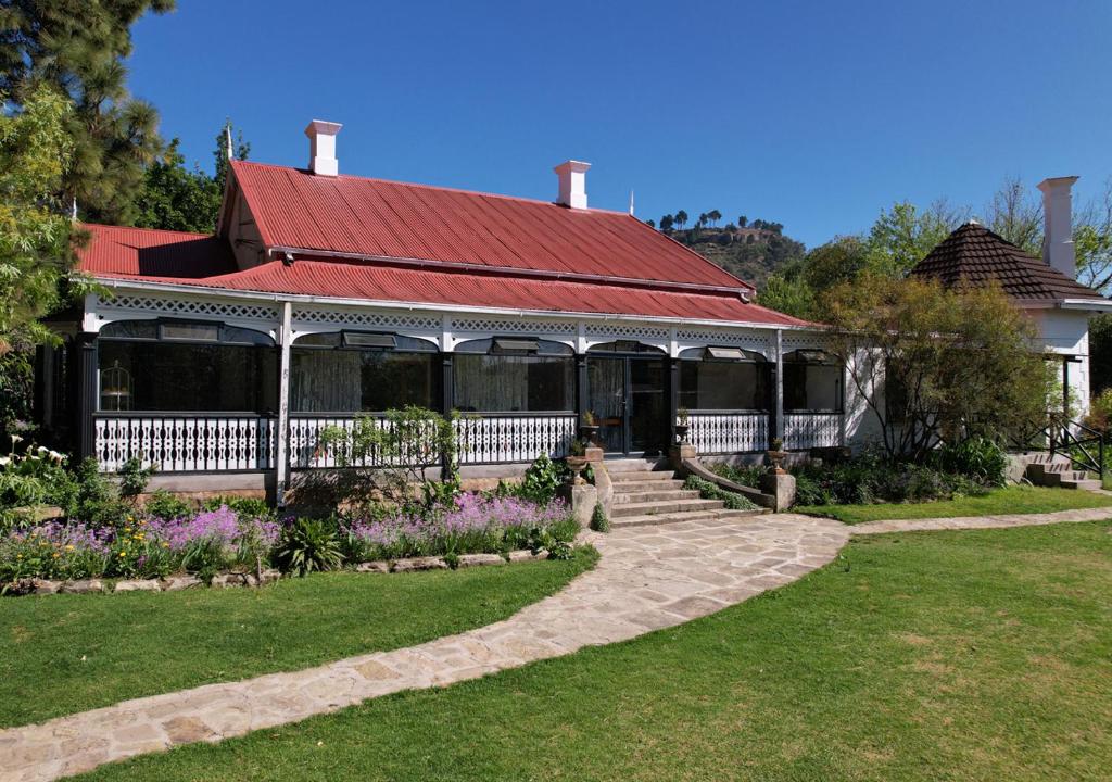 a house with a red roof and a garden at The Victoria House in Ficksburg