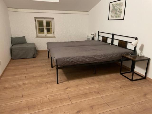 een slaapkamer met een groot bed en een stoel bij Wohnung Salzach in Salzburg