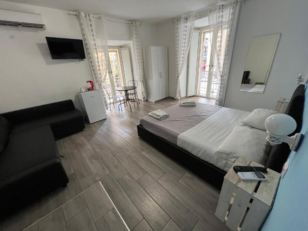 ein Schlafzimmer mit einem großen Bett und einem Tisch in der Unterkunft NAPOLI VIBES Rooms in Neapel