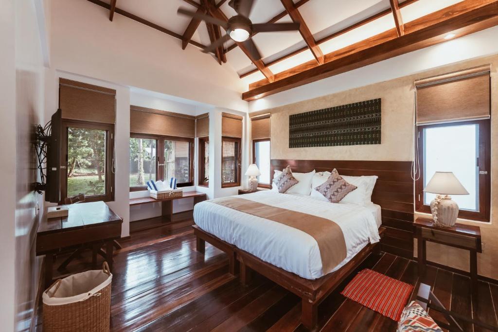 a bedroom with a large bed and wooden floors at ALON CLOUD9, beach front in Catangnan