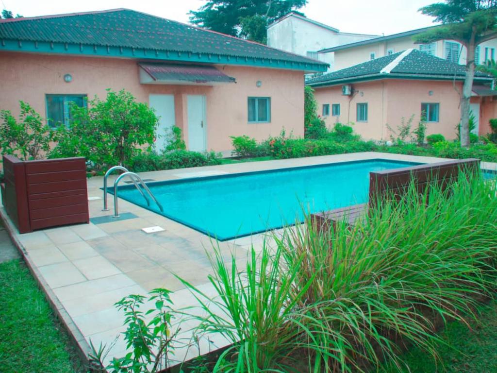 a swimming pool in a yard next to a house at Studio piscine makosso in Pointe-Noire