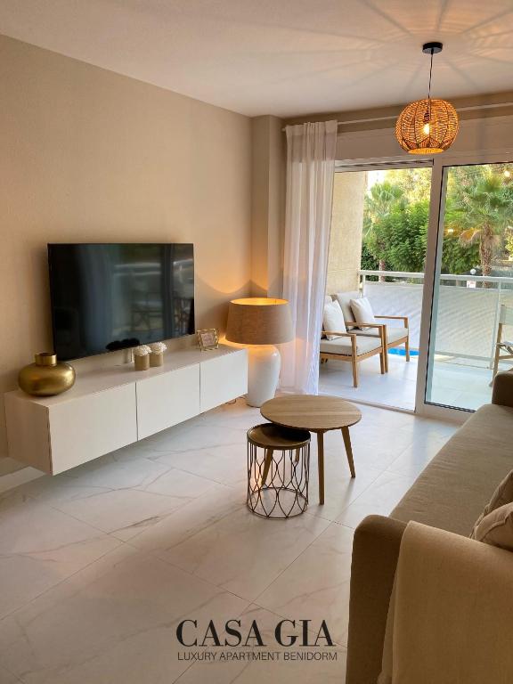 uma sala de estar com uma televisão e um sofá em CASA GIA l Luxury apartment Benidorm em Benidorm