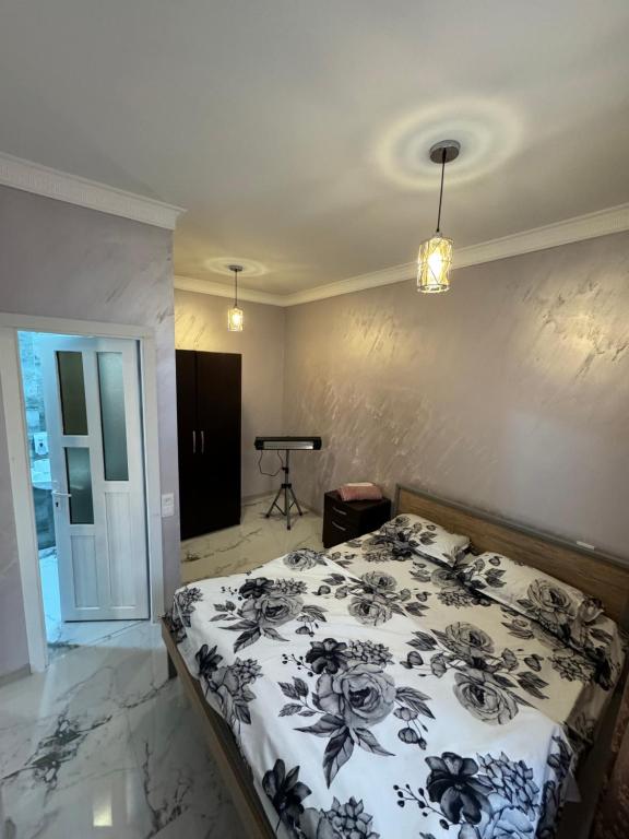 1 dormitorio con 1 cama con edredón blanco y negro en Urartu Complex, en Ereván