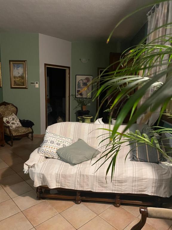 un sofá en una sala de estar con una planta en Il giardino di Emilia, en Pontirolo Nuovo